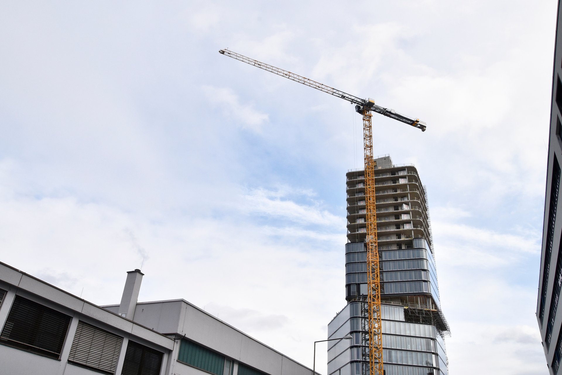 Yellow Tower Crane Beside the Concrete Building